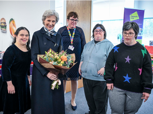 Her Royal Highness The Duchess of Gloucester holding a bouquet of flowers surround by 4 people
