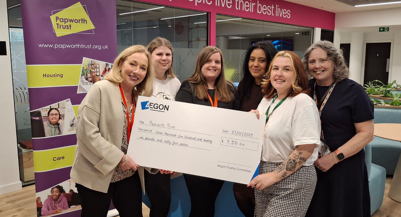 An image of our Fundraiser Pippa standing with the team from Aegon who are holding a cheque